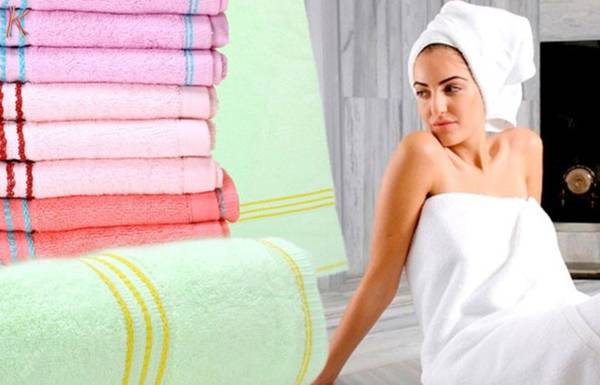 alt text: Hình ảnh một chiếc khăn tắm được trải trên bãi biển với nền là biển xanh và cát trắng.